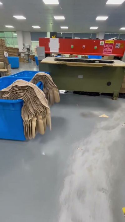 Cutting equipment and stacked material in a production workspace.