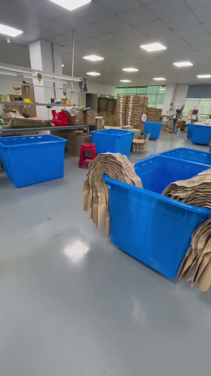 Blue material bins and stacked components in a production workspace.