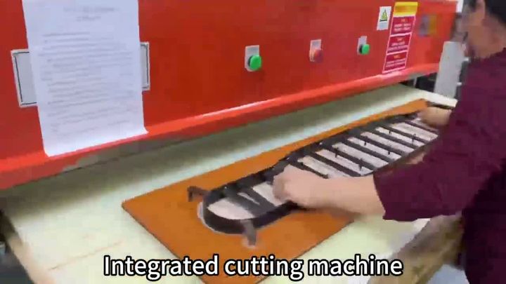 Worker loading a die-cutting press in the Xinlikang workshop.